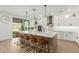 Bright open-concept kitchen with large island, white cabinets, and bar stool seating at 6404 W Black Hill Rd, Phoenix, AZ 85083
