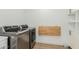 Modern laundry room featuring stainless steel washer and dryer, folding table, and white cabinets at 6404 W Black Hill Rd, Phoenix, AZ 85083