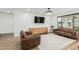 Well-lit living area with neutral decor, wood floors, modern media center and modern sofas at 6404 W Black Hill Rd, Phoenix, AZ 85083