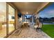 Extended covered patio with outdoor seating, a lush green lawn, and seamless indoor-outdoor living at 6404 W Black Hill Rd, Phoenix, AZ 85083