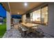Covered patio with a large wooden table and chairs, with views of the interior through sliding glass doors at 6404 W Black Hill Rd, Phoenix, AZ 85083