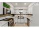 Bright kitchen featuring white cabinets, stainless steel appliances, and a stainless steel farmhouse sink at 6917 E Flossmoor Ave, Mesa, AZ 85208