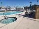 Community pool with lounge chairs and umbrellas and hot tub for relaxing under the warm sunshine at 7807 E Main St # Cc51, Mesa, AZ 85207