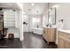 Modern bathroom featuring a freestanding tub, walk-in closet, and dual wood vanities at 7849 W Kristal Way, Glendale, AZ 85308