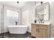 Modern bathroom with black fixtures, a freestanding tub, and a wood vanity at 7849 W Kristal Way, Glendale, AZ 85308