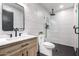 Modern bathroom with a walk-in shower, wood vanity, and white textured walls at 7849 W Kristal Way, Glendale, AZ 85308