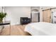 Bedroom featuring wood floors and a modern black crib and barn door at 7849 W Kristal Way, Glendale, AZ 85308