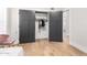 Stylish bedroom featuring gray closet doors, hardwood floors, and a view into the next room at 7849 W Kristal Way, Glendale, AZ 85308