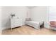 Bedroom featuring light wood floors, a decorative dresser, and a twin bed at 7849 W Kristal Way, Glendale, AZ 85308