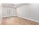 Empty bedroom featuring a large window, light hardwood floors, and neutral paint at 7849 W Kristal Way, Glendale, AZ 85308