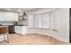 Bright breakfast nook featuring white cabinets, floating shelves, hardwood floors and plenty of natural light at 7849 W Kristal Way, Glendale, AZ 85308