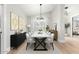Bright dining room with a modern table, stylish light fixture, and elegant decor at 7849 W Kristal Way, Glendale, AZ 85308