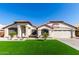 Beautiful single-story home with well-kept landscaping, an American flag, and a two car garage at 7849 W Kristal Way, Glendale, AZ 85308
