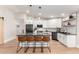 Modern kitchen featuring white cabinets, stainless steel appliances, breakfast bar, and hardwood floors at 7849 W Kristal Way, Glendale, AZ 85308