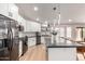 Bright kitchen featuring white cabinets, stainless steel appliances, breakfast bar, and hardwood floors at 7849 W Kristal Way, Glendale, AZ 85308