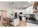 Modern kitchen featuring white cabinets, stainless steel appliances, breakfast bar, and hardwood floors at 7849 W Kristal Way, Glendale, AZ 85308