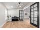 Open living room featuring a grand piano, hardwood floors, modern lighting, and black french doors at 7849 W Kristal Way, Glendale, AZ 85308