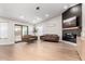 Spacious living room with hardwood floors, a modern fireplace, leather furniture, and natural light at 7849 W Kristal Way, Glendale, AZ 85308