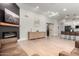 Open concept living room with modern fireplace, hardwood floors, and view into modern kitchen at 7849 W Kristal Way, Glendale, AZ 85308