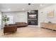Bright living room featuring hardwood floors, a modern fireplace, and leather furniture at 7849 W Kristal Way, Glendale, AZ 85308