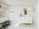 Well-lit bathroom with a white vanity, bench seating near a window, and neutral decor creating a serene atmosphere at 7975 W Griswold Rd, Peoria, AZ 85345