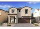 Charming two-story home featuring neutral stucco, a brown roof, and a two-car garage, surrounded by desert landscaping at 7975 W Griswold Rd, Peoria, AZ 85345