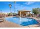 Community pool with covered seating area surrounded by well-maintained landscaping and palm trees at 8923 W Acoma Dr, Peoria, AZ 85381