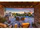 Inviting back patio with a built-in grill, stone fireplace, and views of the pool at sunset at 9677 E Gold Dust Ave, Scottsdale, AZ 85258