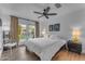 Bright bedroom with hardwood floors, white bedding and a ceiling fan, featuring a backyard view at 9677 E Gold Dust Ave, Scottsdale, AZ 85258