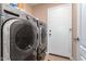 Gray front-loading washer and dryer in the laundry area, with a white door leading to the backyard at 9859 W Irma Ln, Peoria, AZ 85382