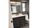 Bathroom featuring modern vanity with black faucet, framed mirror, and tiled flooring at 9862 W Comstock Ct, Sun City, AZ 85373