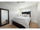 Bright bedroom featuring a queen-sized bed, neutral decor, wood flooring, and a full-length mirror at 1011 E Cavalier Dr, Phoenix, AZ 85014