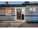 Inviting front entrance featuring a wreath-adorned door, potted flowers, and updated exterior lighting at 1011 E Cavalier Dr, Phoenix, AZ 85014