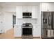 Well-lit kitchen featuring stainless steel appliances, white cabinetry, and a gas range stove at 1011 E Cavalier Dr, Phoenix, AZ 85014