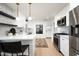 Modern kitchen with white cabinetry, stainless steel appliances, bar seating, and stylish decor at 1011 E Cavalier Dr, Phoenix, AZ 85014