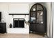 Living area featuring a brick fireplace with dark wood mantle and arched glass cabinet for decor at 1011 E Cavalier Dr, Phoenix, AZ 85014