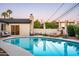 Beautiful outdoor pool area with lounge chairs, umbrellas, and a well-manicured backyard at 1011 E Cavalier Dr, Phoenix, AZ 85014