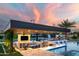 Stylish outdoor kitchen featuring a built-in grill, bar seating, and covered dining area by the pool at 10242 N 57Th St, Paradise Valley, AZ 85253