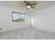 Minimalist bedroom featuring light marble floors and a bright window with a view of the surrounding landscape at 10322 E Breathless Ave, Gold Canyon, AZ 85118