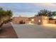 Desert home with a large driveway, stucco exterior, and an attached two-car garage with a door and window at 10322 E Breathless Ave, Gold Canyon, AZ 85118