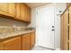 Hallway with wood cabinets, counter, and white door, offers ample storage and workspace at 10322 E Breathless Ave, Gold Canyon, AZ 85118