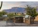 Outdoor built-in kitchen features a bar and grill, perfect for entertaining against a backdrop of mountain views at 10322 E Breathless Ave, Gold Canyon, AZ 85118