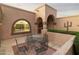 Outdoor living space featuring an archway to the front entrance and an outdoor dining area, for relaxing with friends at 10322 E Breathless Ave, Gold Canyon, AZ 85118