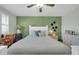 Spacious bedroom with a ceiling fan, white furniture, and a green accent wall at 10350 W Deanne Dr, Sun City, AZ 85351