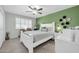 Spacious bedroom with natural light, ceiling fan, white furniture, and a green accent wall at 10350 W Deanne Dr, Sun City, AZ 85351