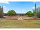 Expansive backyard featuring desert landscaping, mature trees, and a cozy outdoor seating area at 10453 W White Mountain Rd, Sun City, AZ 85351