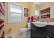 Bathroom featuring a modern vanity, framed mirror, and updated toilet next to bright window at 10453 W White Mountain Rd, Sun City, AZ 85351