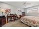 Bright bedroom setup with a vintage desk, wood accents, and a comfortable bed with floral comforter at 10453 W White Mountain Rd, Sun City, AZ 85351