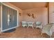 Inviting front porch with decorative chairs, a table, and a beautifully designed door at 10453 W White Mountain Rd, Sun City, AZ 85351