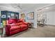 Comfortable living room with a plush red sofa and neutral carpeting at 10453 W White Mountain Rd, Sun City, AZ 85351